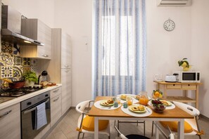 Une cuisine moderne avec un coin repas, comprenant une cuisinière, un four à micro-ondes et une table mise pour le petit-déjeuner.