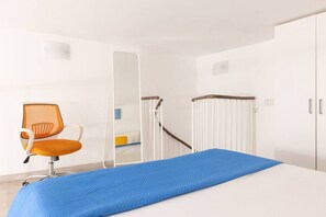 Une salle de consultation équipée d’un lit, d’une chaise, d’un miroir et d’une porte blanche.