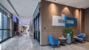 A modern hotel lobby with a marble floor, seating areas, and artwork on the walls. - Holiday Inn Express Chongqing Nanbin Road by IHG (Chongqing)
