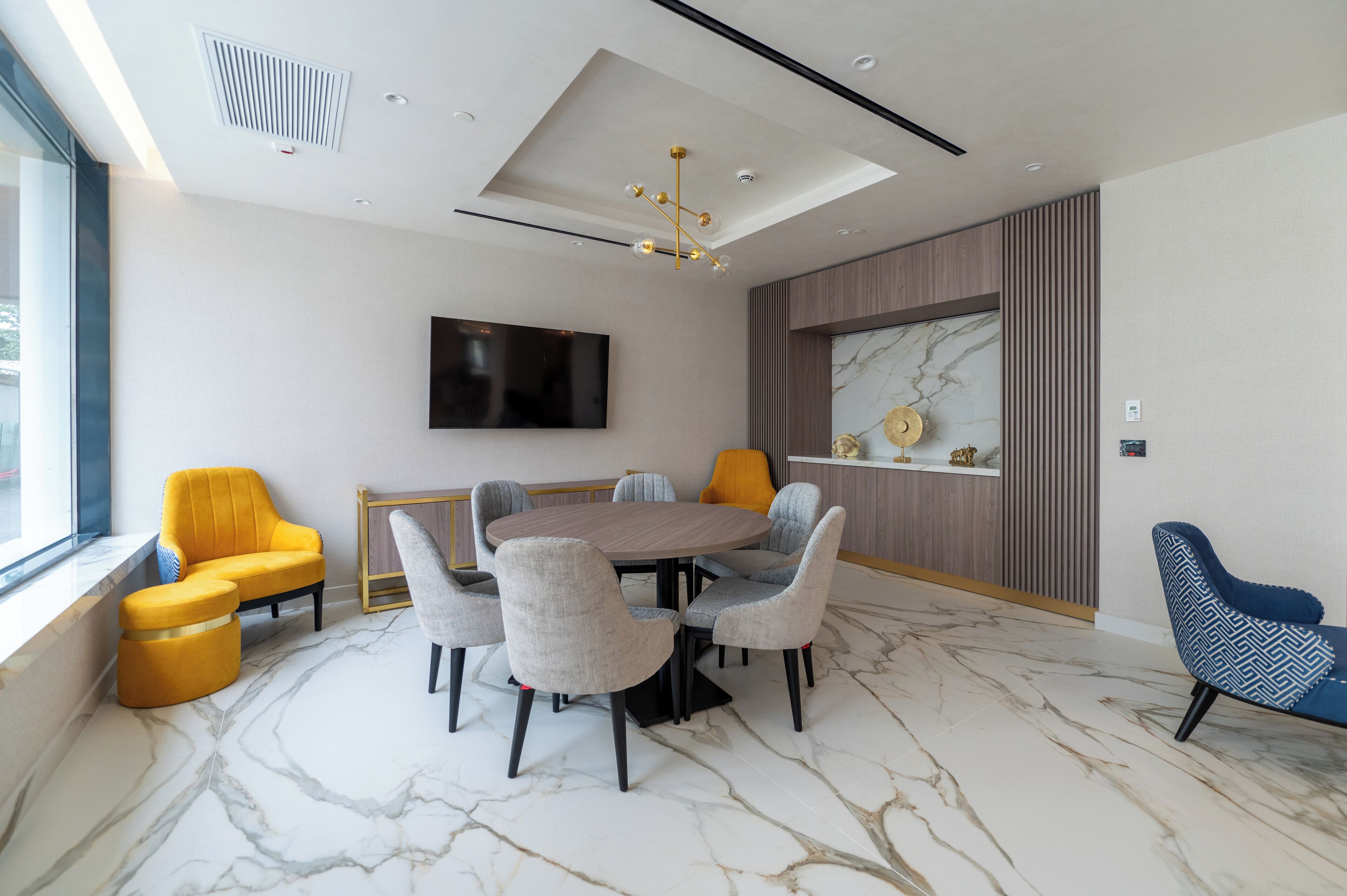 A modern conference room with a marble floor, a round table, and six chairs.