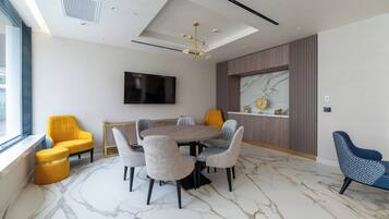 A modern conference room with a marble floor, a round table, and six chairs.