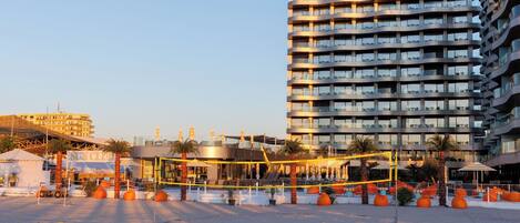 Un hotel moderno con varios balcones y una terraza en la azotea.