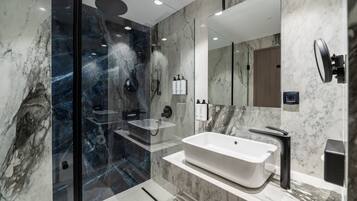 A modern bathroom with a glass-enclosed shower, a freestanding bathtub, and a large mirror.