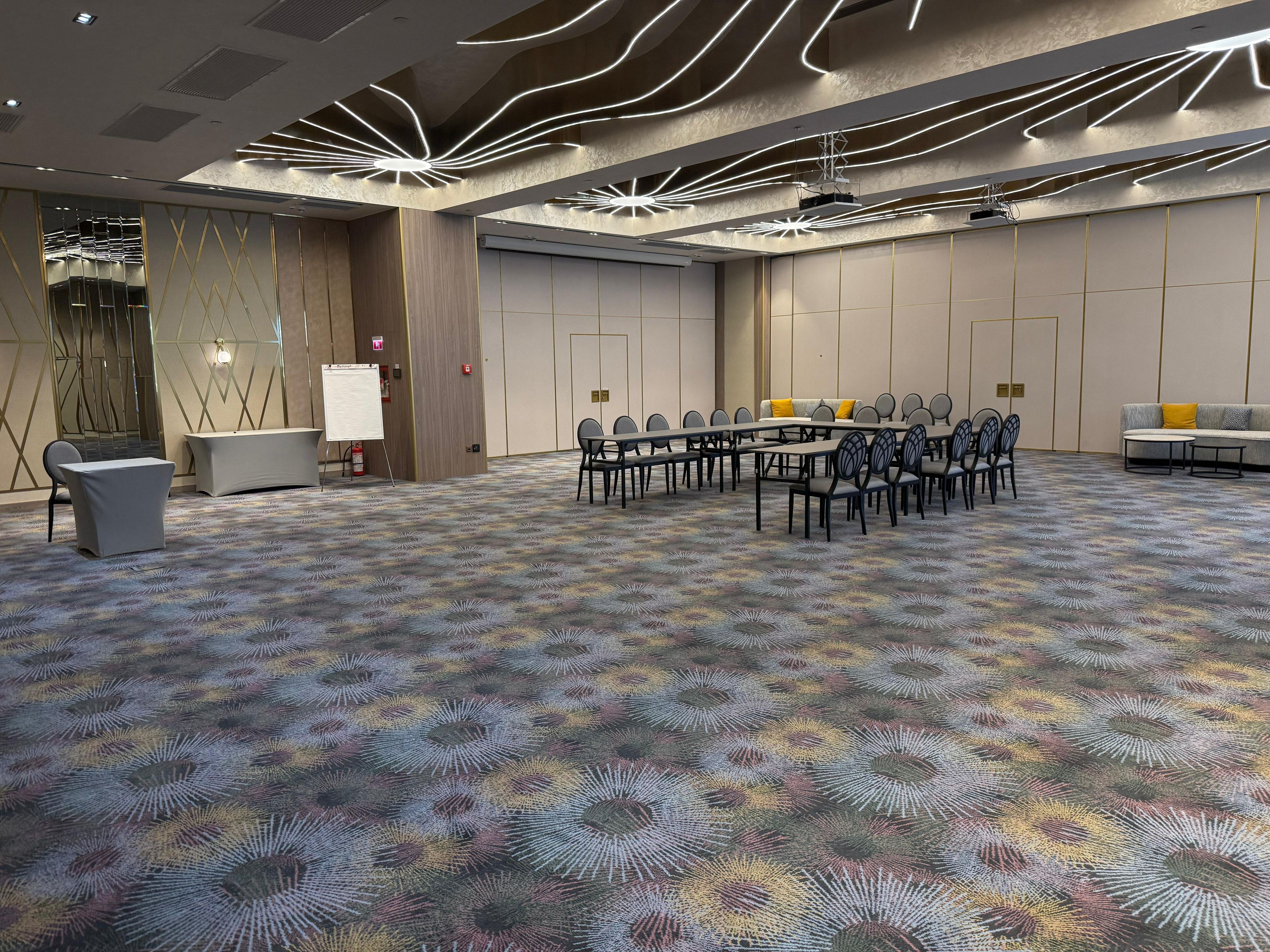 Un salón de conferencias con una larga mesa, sillas y una pizarra.