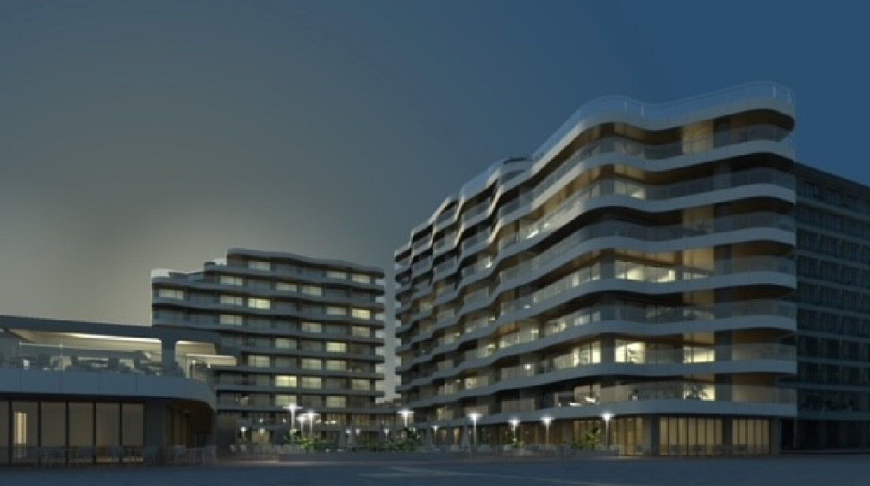 A modern multi-story hotel with a curved facade and balconies.