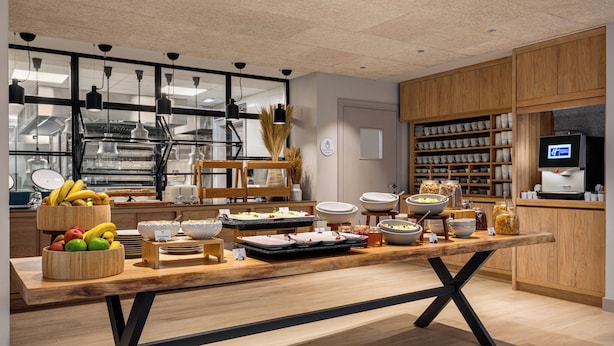A buffet setup with various food items and a television screen. - Holiday Inn Express Porto Boavista by IHG (Porto)