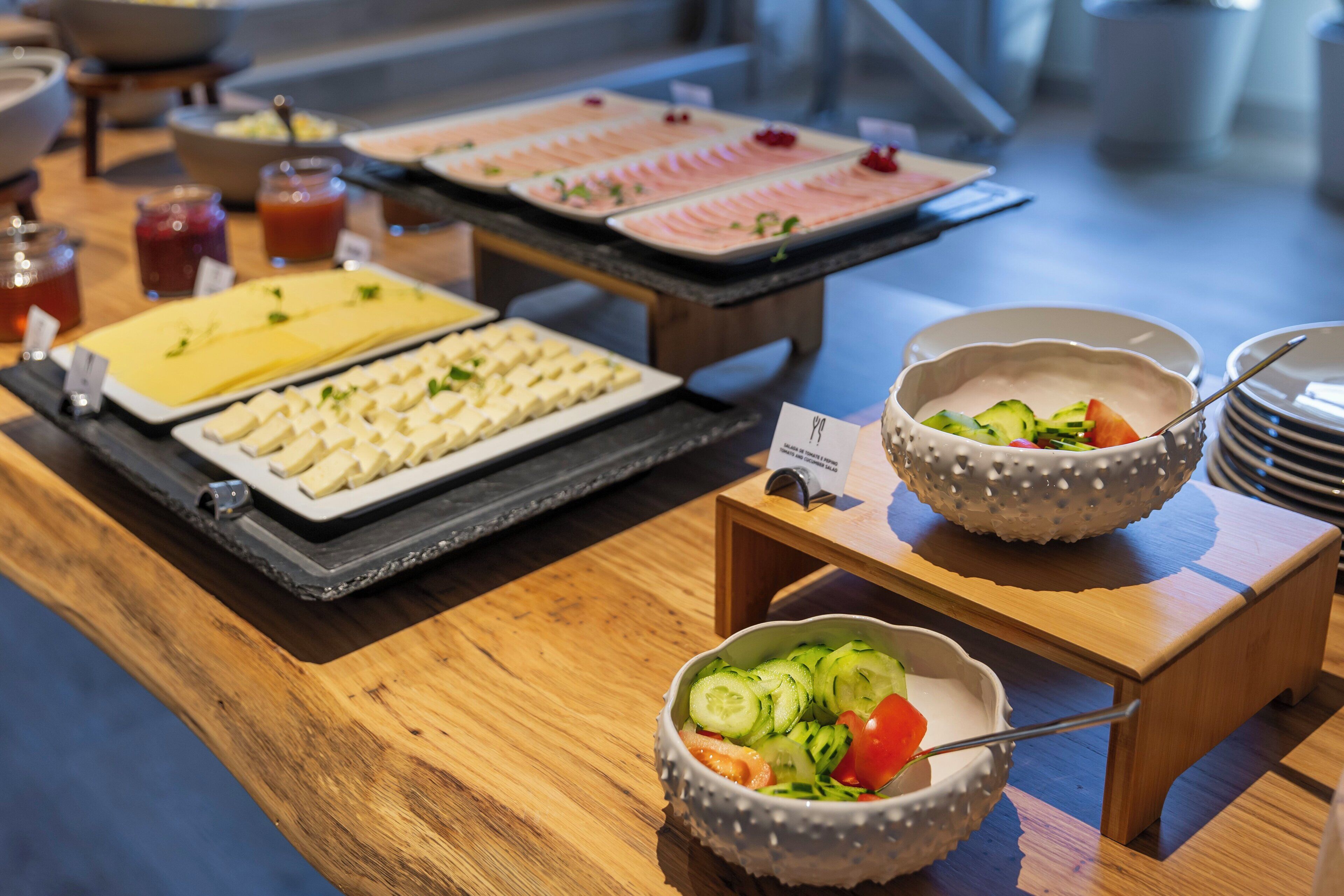 A buffet with various food items and a small bowl of salad.