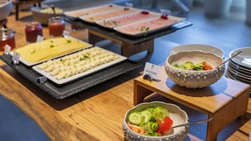 A buffet with various food items and a small bowl of salad.