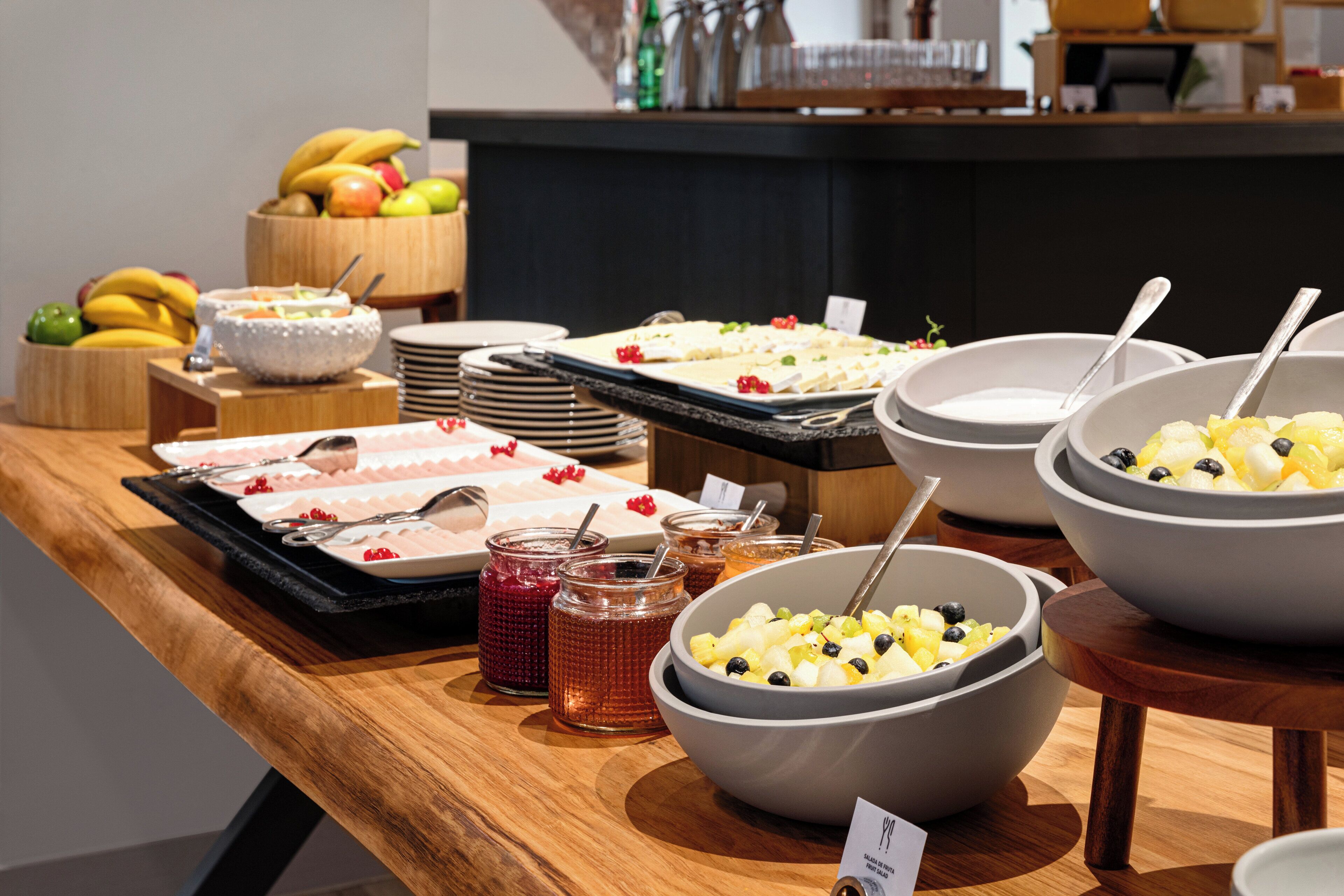 A buffet table with various food items and serving utensils.