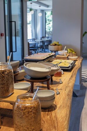 Een buffet met diverse gerechten en serveerbekers.