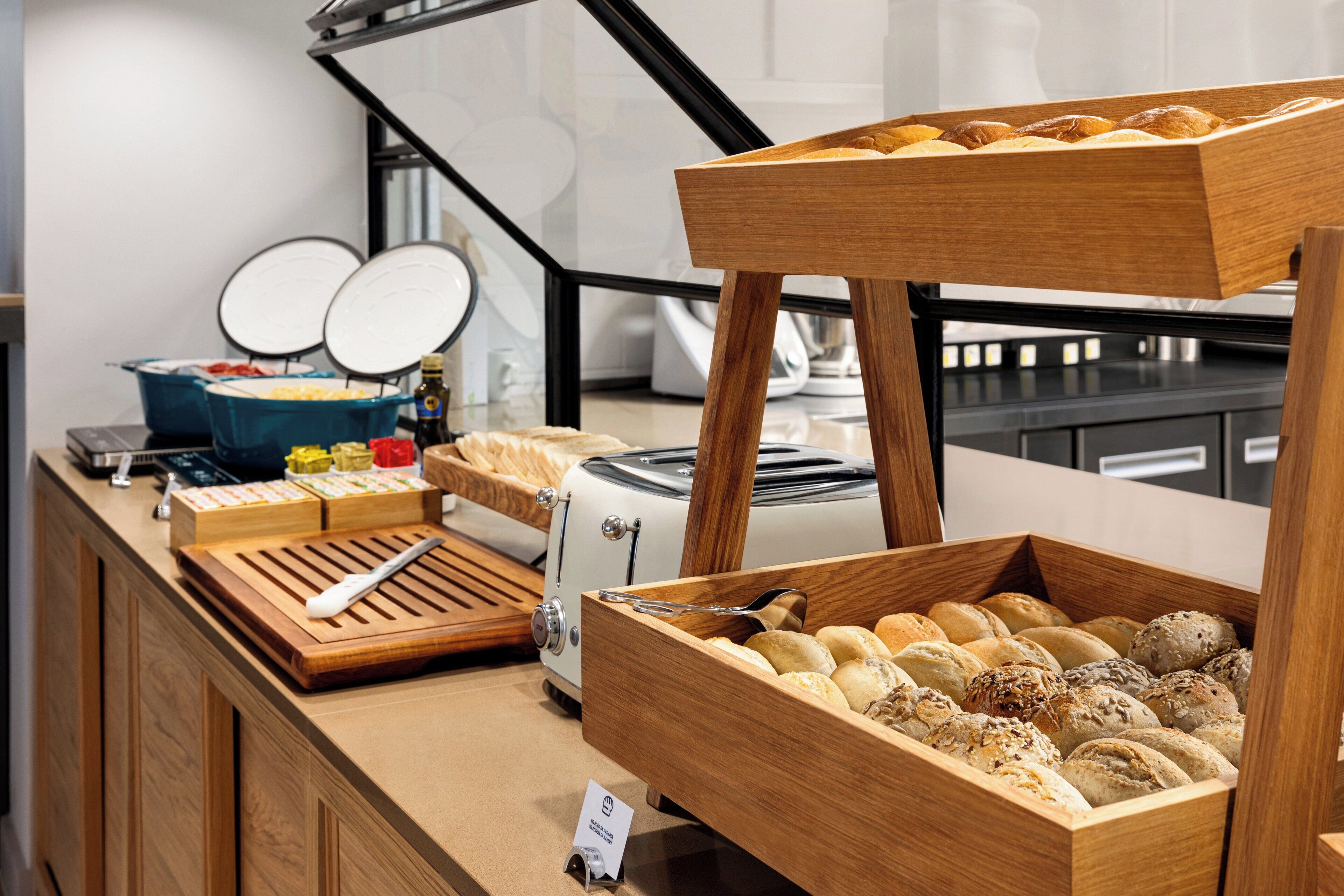 Um balcão de buffet com diversos alimentos e uma torradeira.