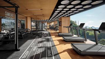 A modern gym with treadmills, weight machines, and a motivational quote on the wall.