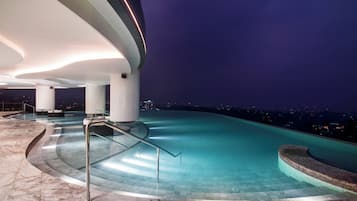 Swim and unwind in a spacious pool area with a unique ceiling design and city views.