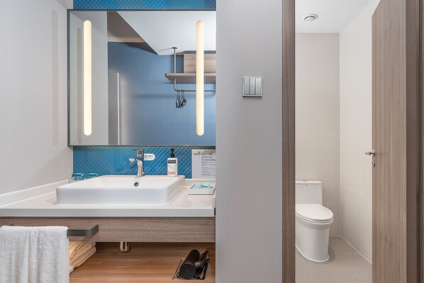 A modern bathroom with a large mirror, two sinks, a toilet, and a towel rack. - Holiday Inn Express Xiamen Jimei New Town by IHG (Xiamen)