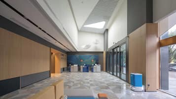 A modern reception area with a check-in counter, seating area, and a patterned floor.