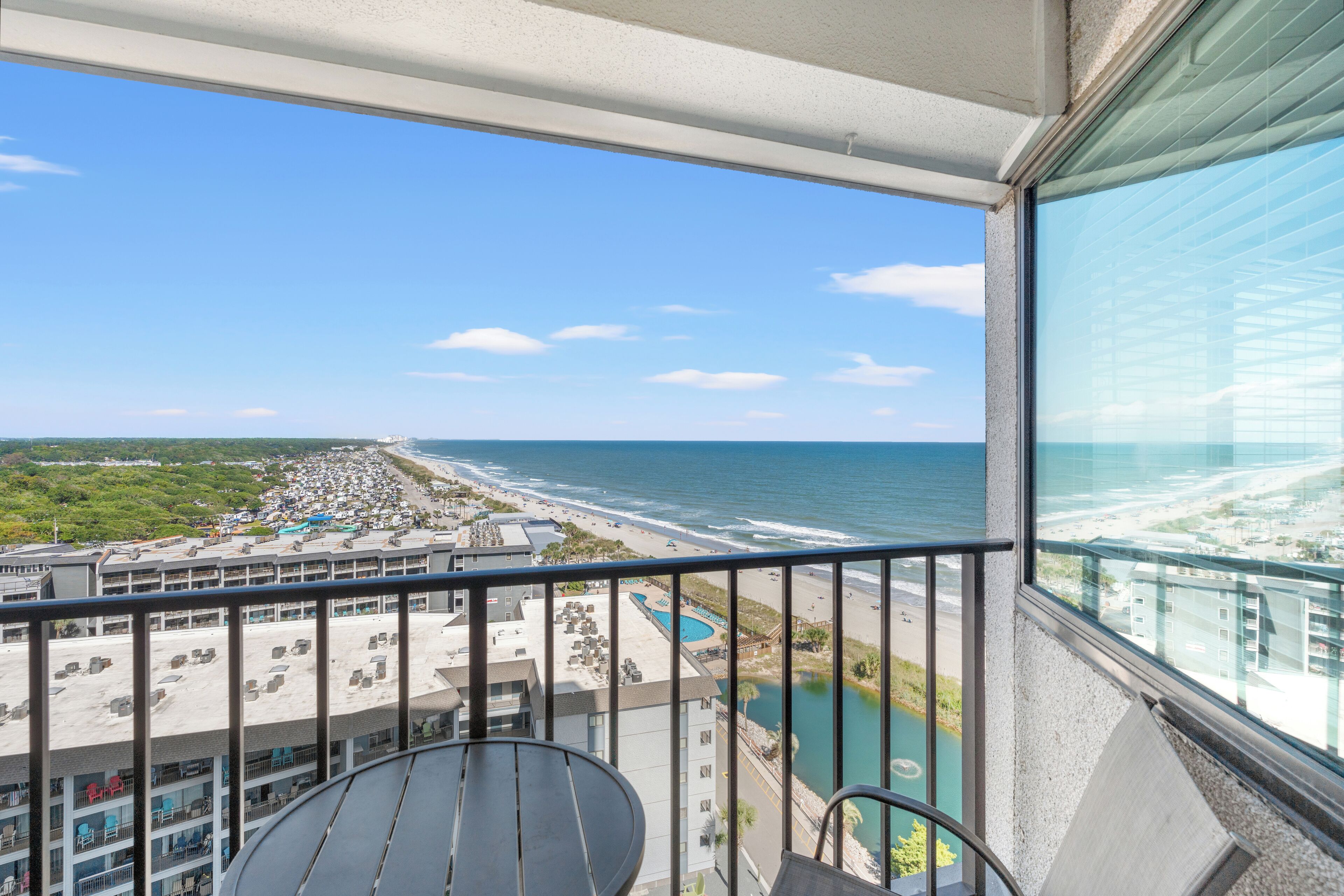 A balcony with a view of the beach and ocean.