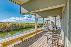 A wooden deck with a hammock and chairs overlooking a body of water and marshland. - Ocean front villa taking in all views, walking distance to BHI Club; access to both clubs! (Bald Head Island)