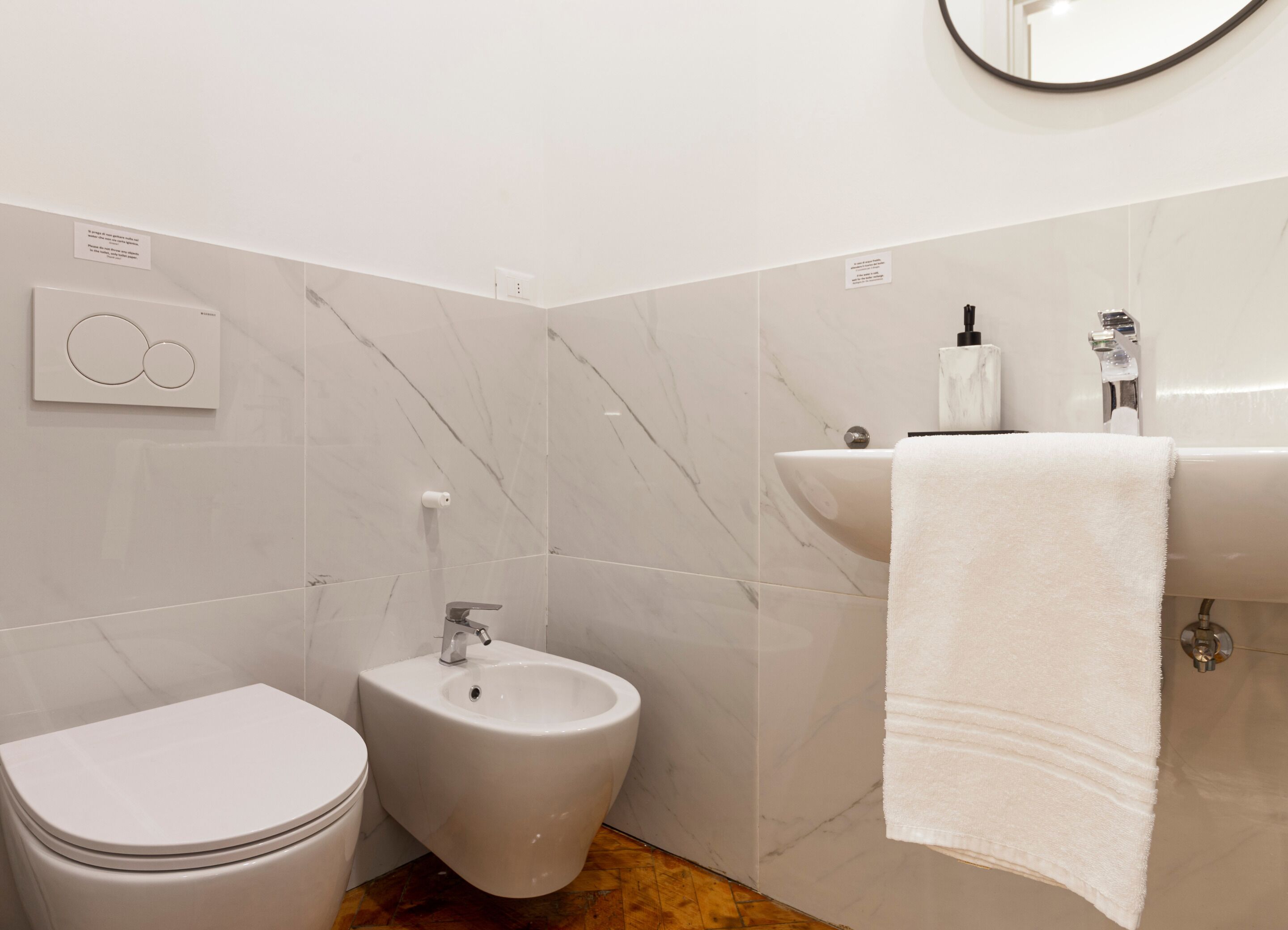 Uma casa de banho moderna com sanita, bidé e lavatório.