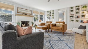 Un salon moderne doté d’une cheminée, de sièges confortables et d’un ventilateur de plafond.