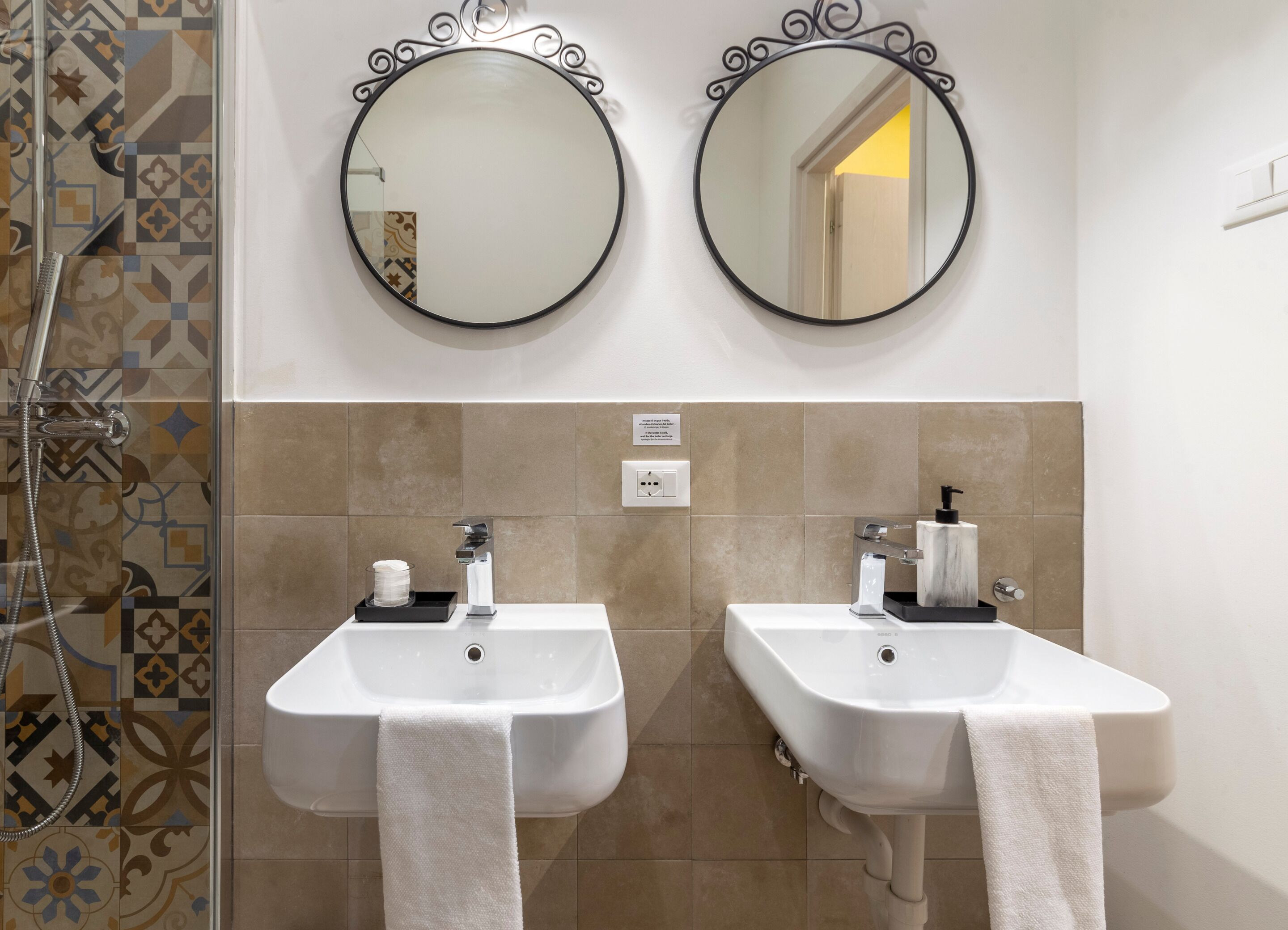 A bathroom with two sinks, each with a towel, and two wall-mounted mirrors.