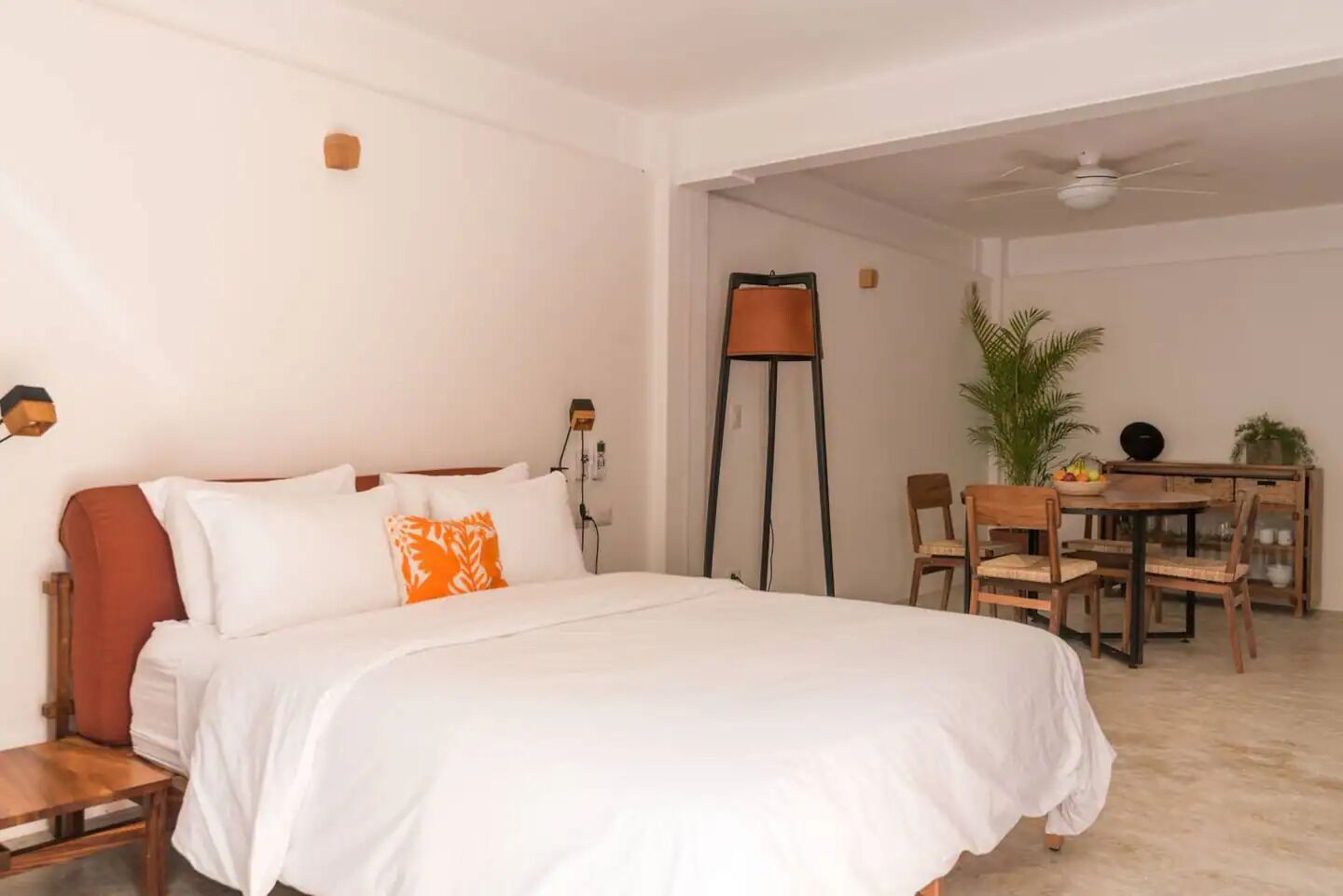 A hotel room with a bed, a desk, and a dining table with chairs.