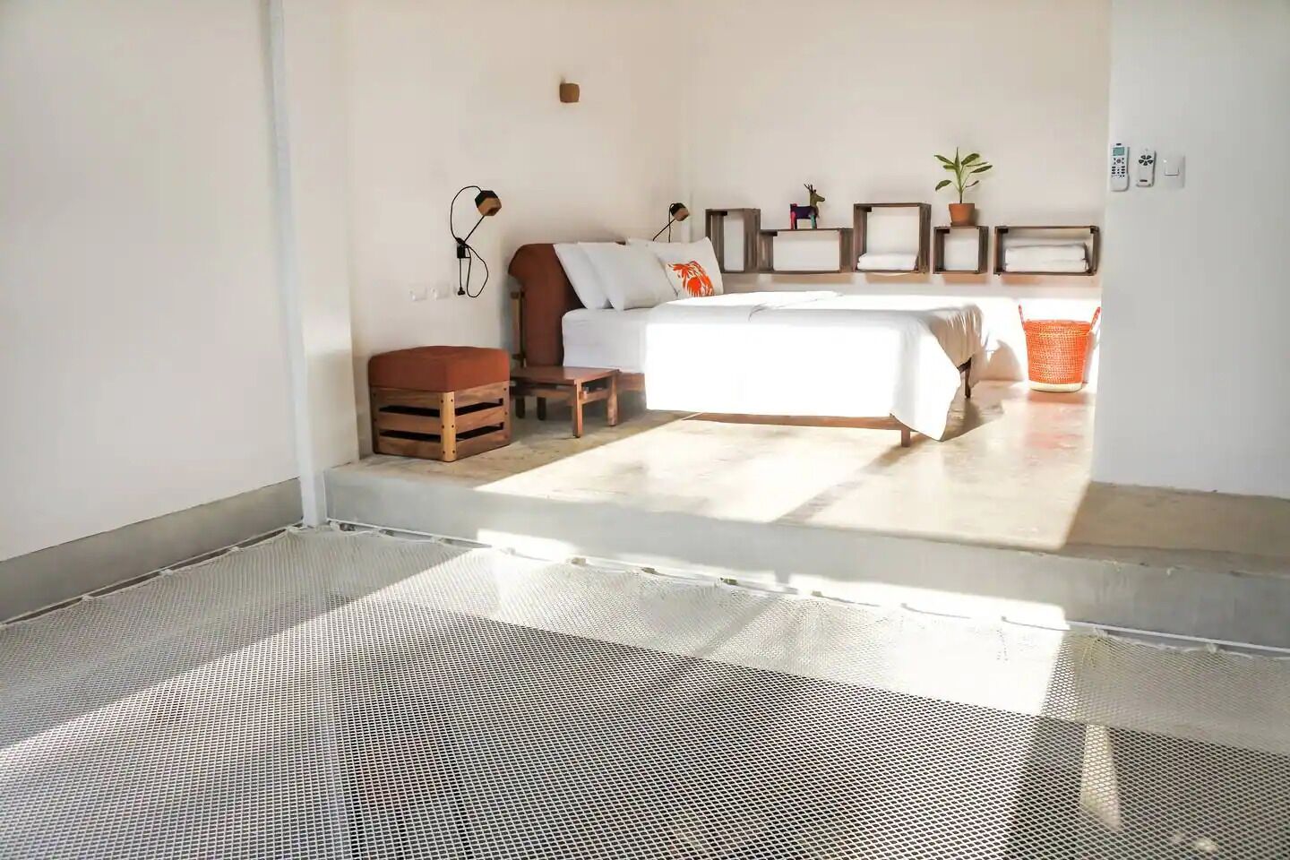 A bedroom with a bed, a chair, a small table, and a shelf with decorative items.