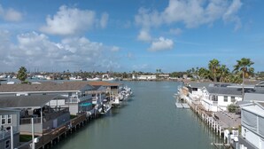 A marina with docked boats, waterfront houses, and palm trees. - Long Island Village Texas (Port Isabel)