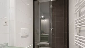 A modern bathroom with a glass-enclosed shower, a toilet, and a sink. - Studio Bon'Air - Welkeys (Biarritz)
