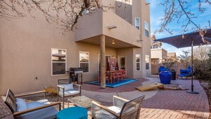 Un espace extérieur aménagé en terrasse, avec des meubles en osier, une table et des chaises.