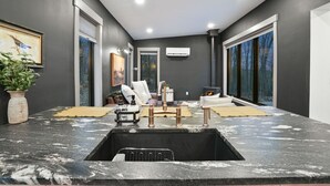 Een modern interieur met een keukeneiland, zithoek en een open haard.