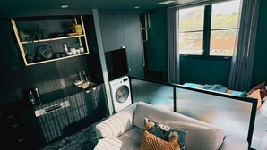 A modern living room with a sofa, a coffee table, and a view of the outside through a window.