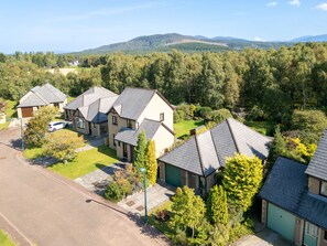 Ett bostadsområde med flera hus, alla med sluttande tak och omgivna av grönska.