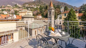 A balcony with a table, chairs, and a book. - Blue Diamond by Interhome (Bellano)