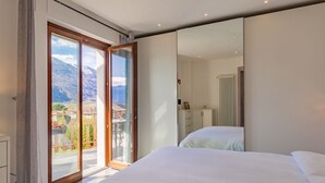 Makuuhuoneessa on suuri sänky, lasiliukuovi, joka johtaa parvekkeelle, jolta avautuu näkymä vuorille, sekä valkoinen vaatekaappi.
