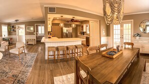 Un salón espacioso con sofá, una mesa de centro y un comedor con mesa y sillas de madera.