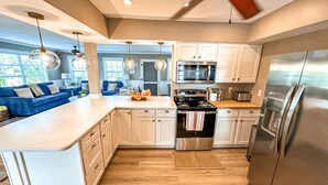 Una cocina moderna con armarios blancos, electrodomésticos de acero inoxidable y una isla grande.