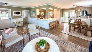 Un salón amplio con una isla grande, una zona de comedor y una cocina con barra.