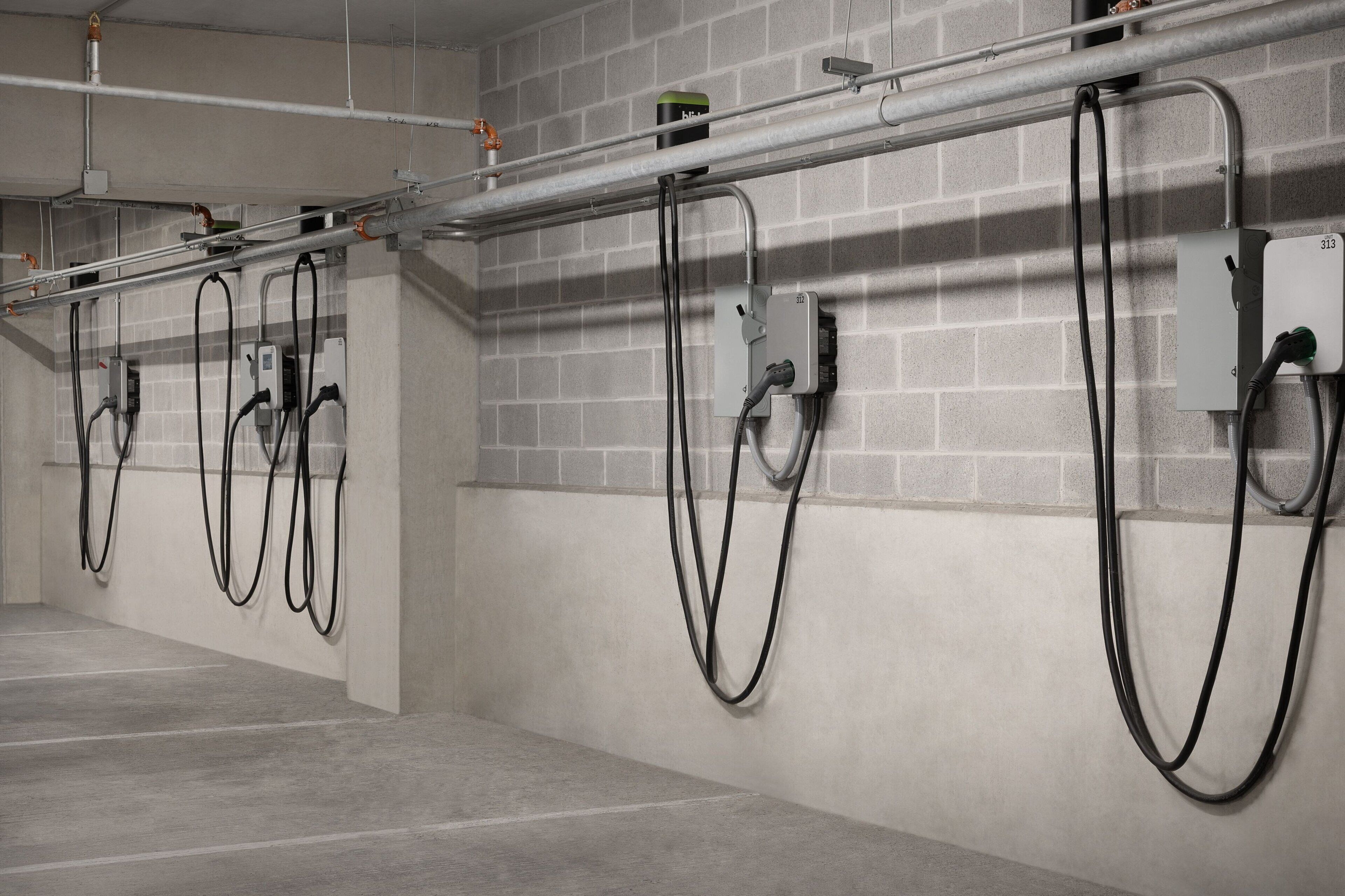 A parking garage with multiple charging stations for electric vehicles.