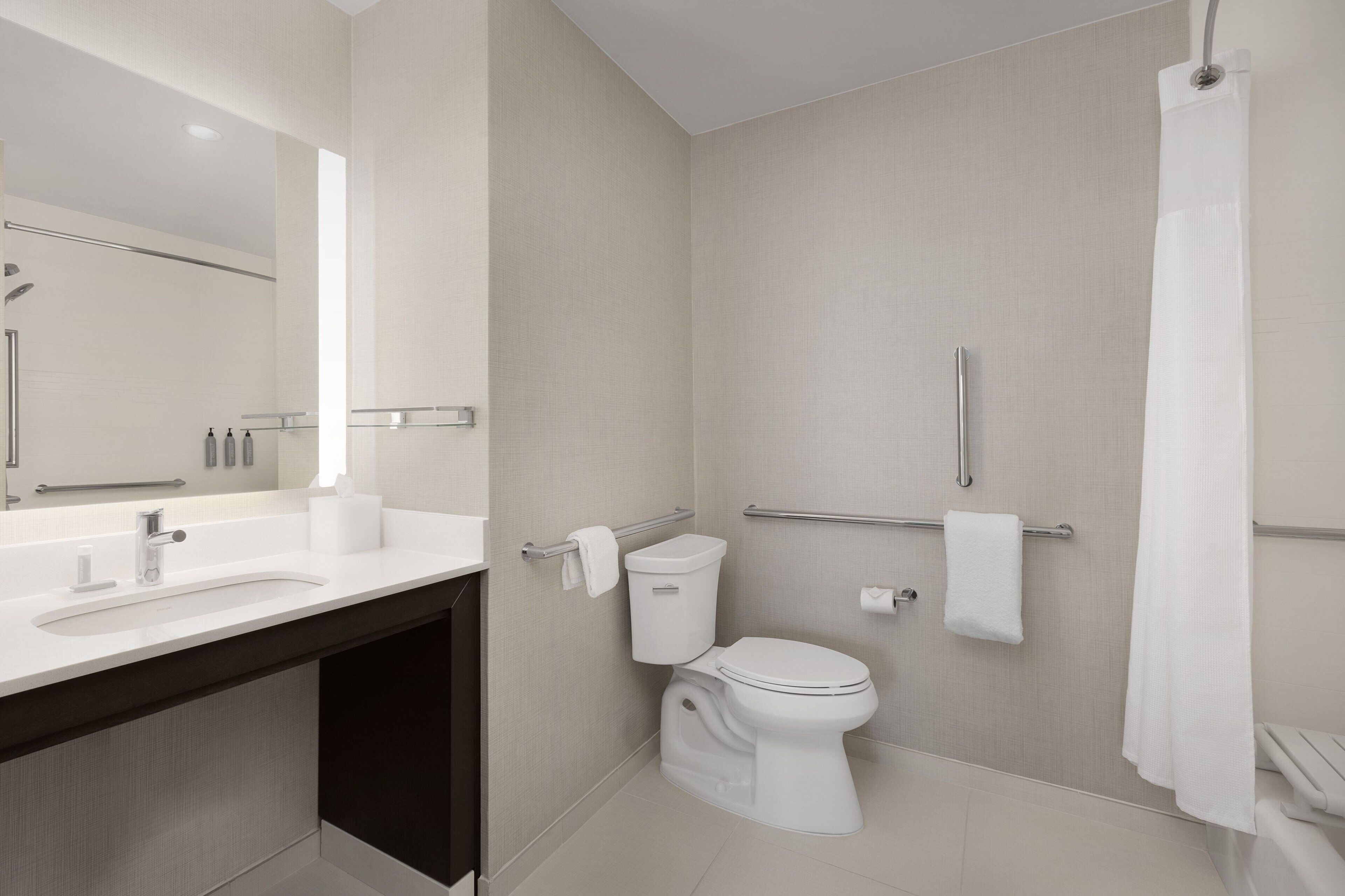 A modern bathroom with a toilet, bidet, and a shower area.