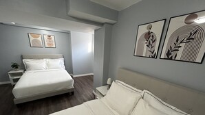 A modern bedroom with a large bed, bedside tables, and artwork on the walls. - Cozy basement apartment in Brampton  (Brampton)