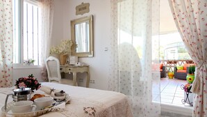 A bedroom with a bed, a desk, a chair, and a window with curtains. - Amazing place with large terrace and BBQ (Mijas Costa)