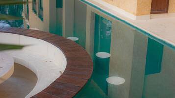 Una piscina de borde curvo, una ventana y una puerta al fondo.
