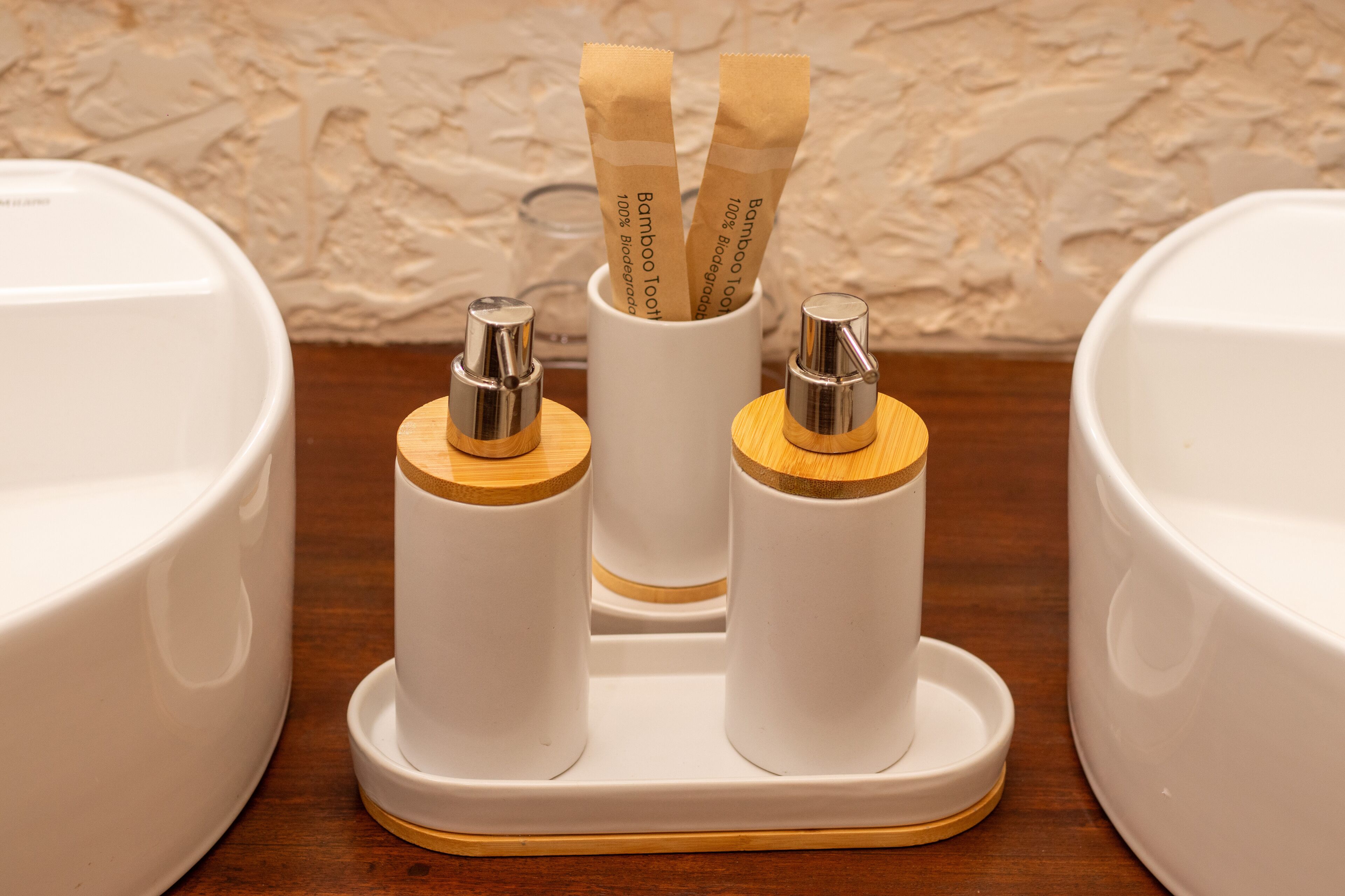 A bathroom with two sinks, each with a white faucet and a wooden base.