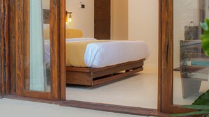 Quarto com estrutura de cama de madeira, mesa de cabeceira e criado-mudo.