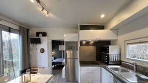 Eine moderne Küche mit Essbereich, Backofen, Mikrowelle und Geschirrspüler.