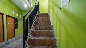 Eine Treppe mit Metallgeländer, die zu einer Tür mit einem Schild führt.