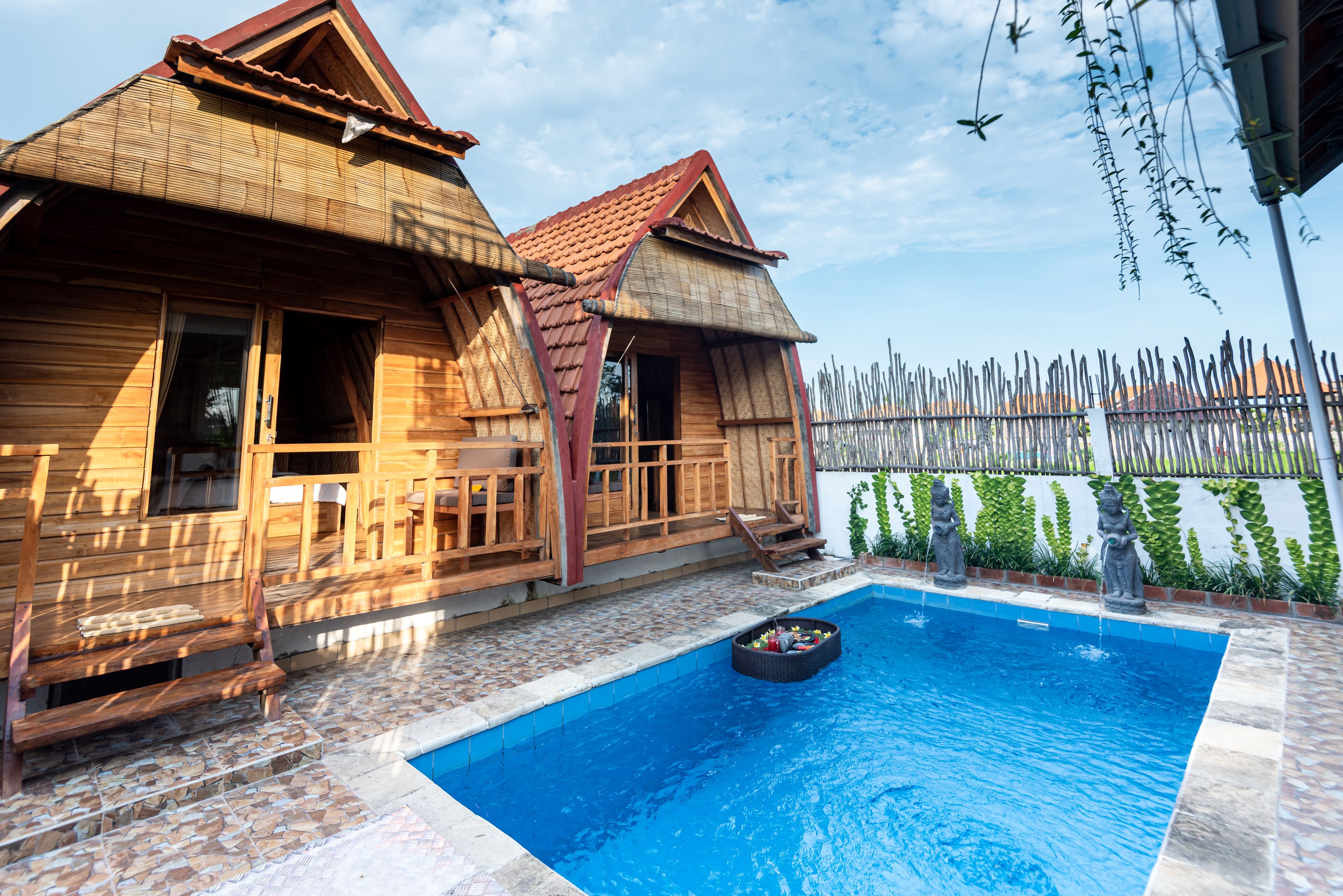Une cabane en bois avec une piscine, une terrasse en bois et un jardin clos.