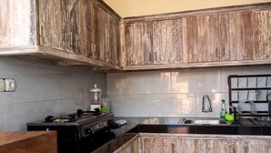 A kitchen with wooden cabinets, a stove, and a sink. - Ulun Si Joglo Private Villa by Supala (Ubud)