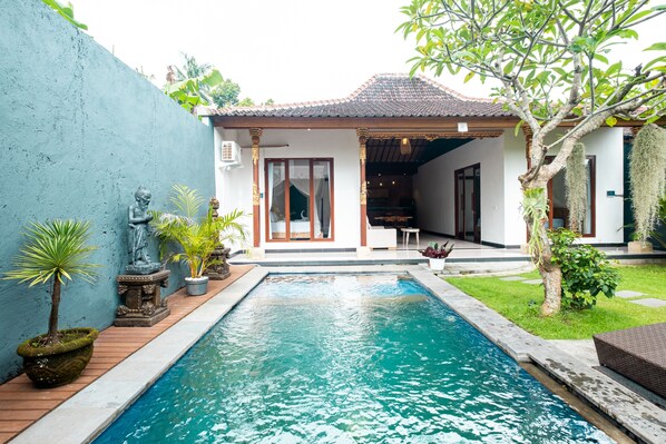 Una piscina al aire libre, tumbonas