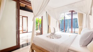 A spacious bedroom with a large bed, white curtains, and a view of the outdoors.